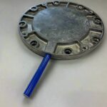 A gray base plate with multiple mounting holes and a blue tube attached to it.